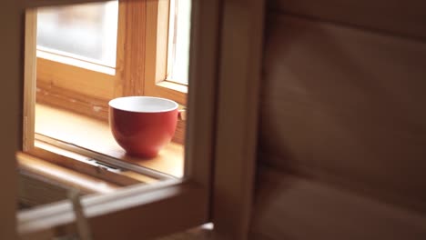 red cup on a wooden windowsill