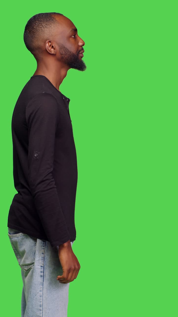 Vertical video: Profile of confident relaxed person posing in studio