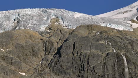 Waterfall-On-The-Rocky-Wall-Of-Joffre-Mountain-With-Glacier-On-The-Summit-On-A-Sunny-Day