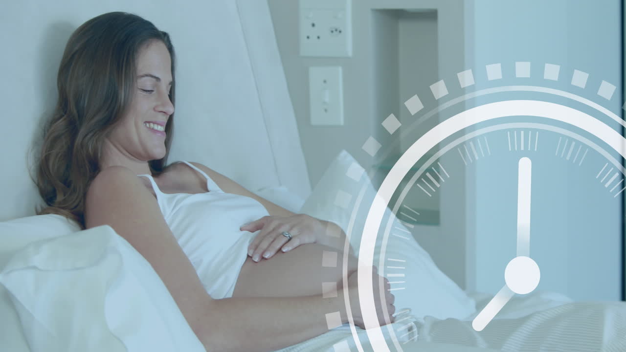 Clock with fast moving hands over happy pregnant caucasian woman lying on bed holding belly
