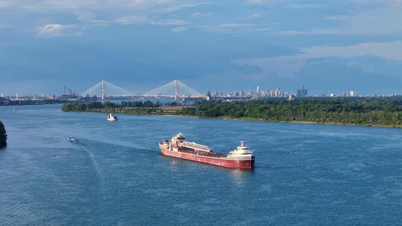 Bulk carrier on Detroit River with Detroit skyline and Gordie Howe International Bridge