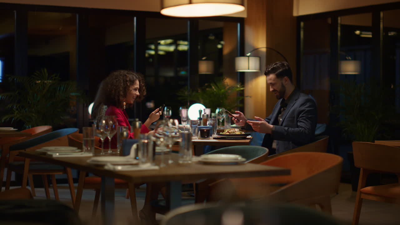Par bruger mobiltelefon til at tage en selfie på restaurant. Kærester fejrer sammen