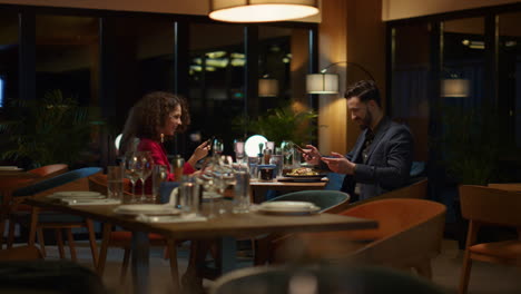 couple using mobile phone taking selfie in restaurant. lovers celebrate together