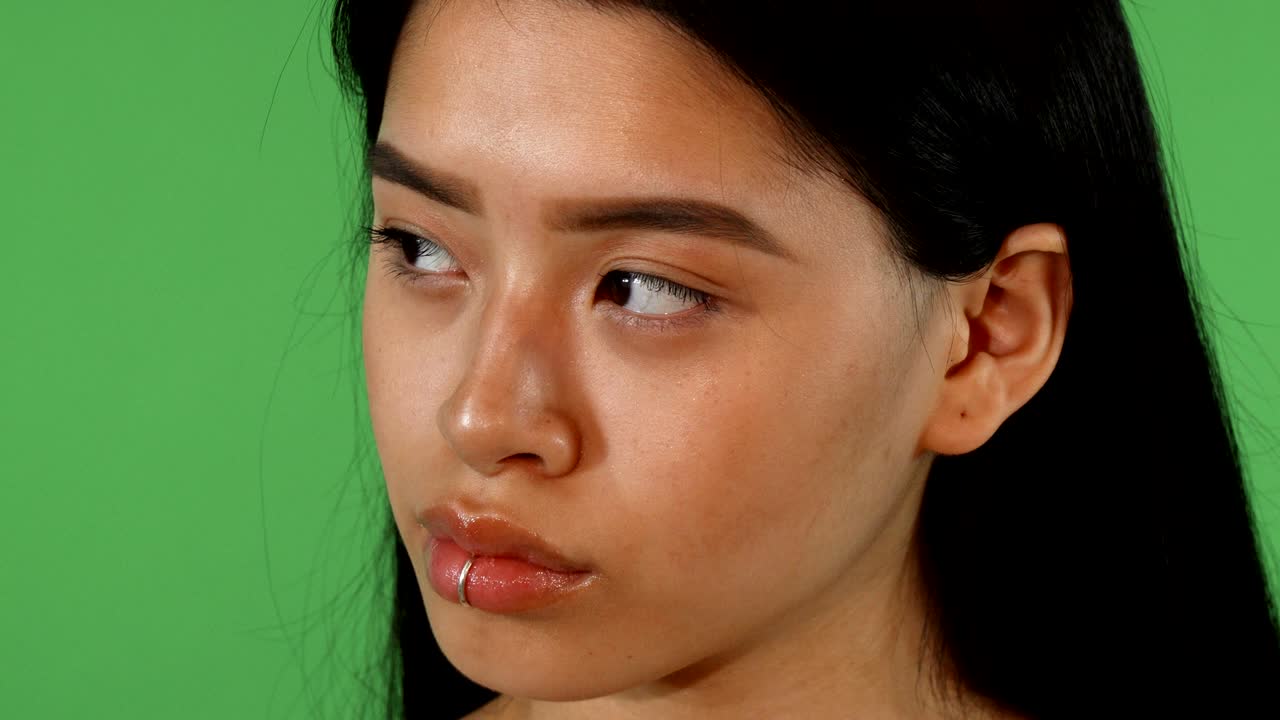 Beautiful young Asian woman with lip piercing smiling to the camera