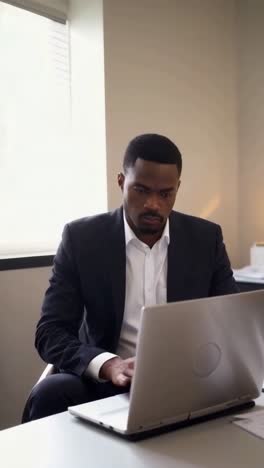 afro businessman working with laptop in office.