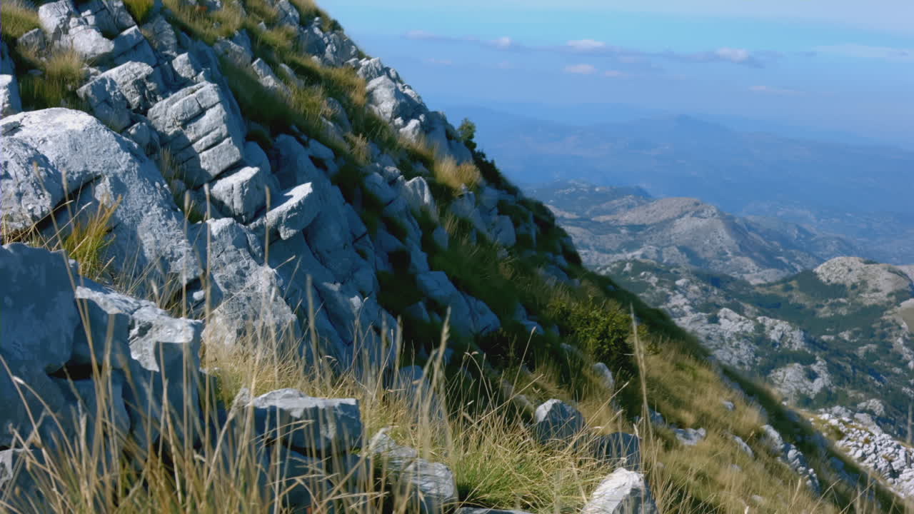 paisaje montañoso con pendiente rocosa y hierba