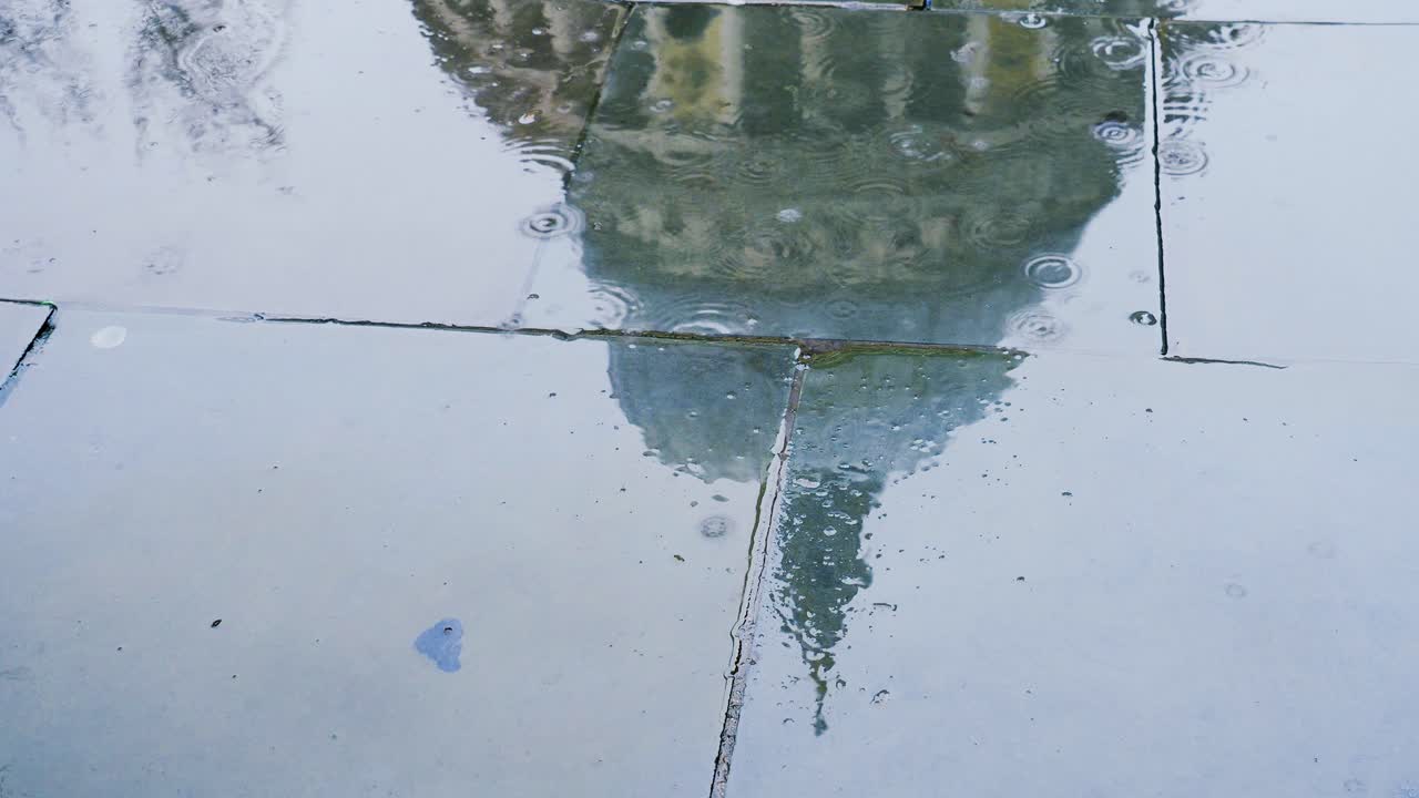 Reflection of the dome of St Paul's Cathedral in a wet and rain soaked pavement