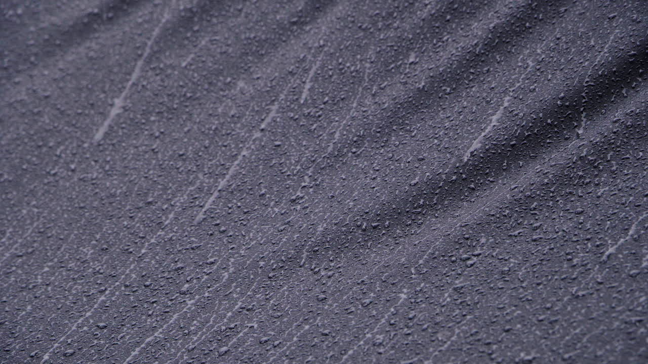 lluvia intensa corriendo sobre textil impermeable negro-1