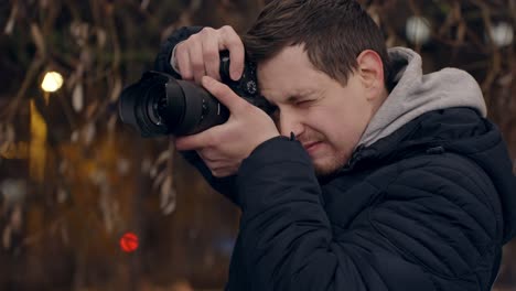 Photographer-takes-photos-in-city-at-night,-closeup