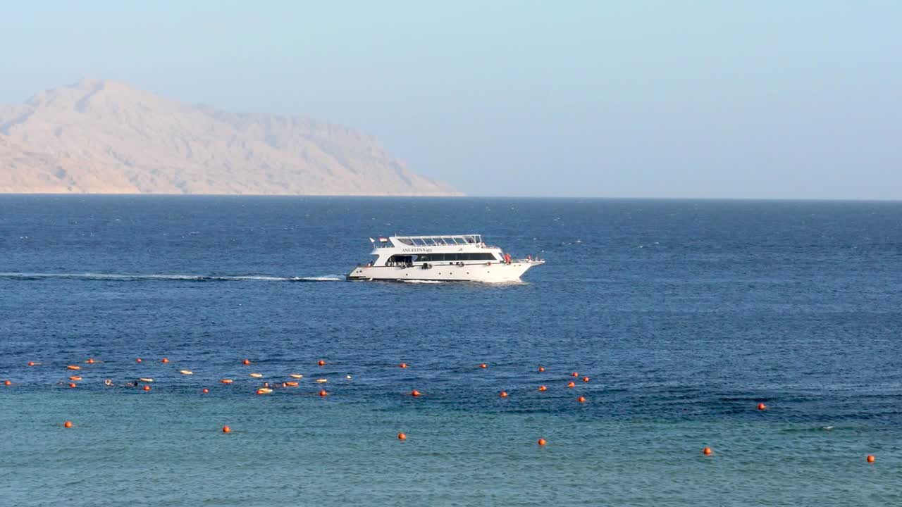 Arka planda çöl kumlu adasıyla denizde seyreden yat, Kızıldeniz, Şarm El-Şeyh, Mısır.