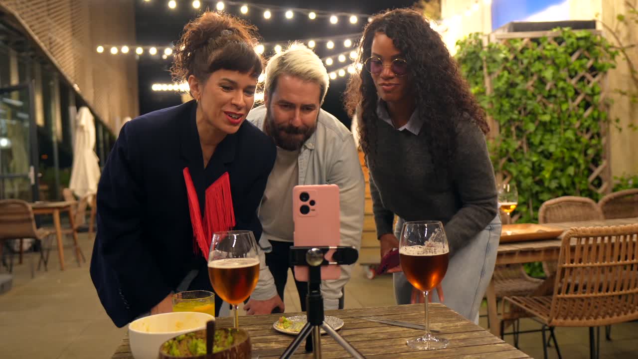 A group of friends are taking a selfie at an outdoor party