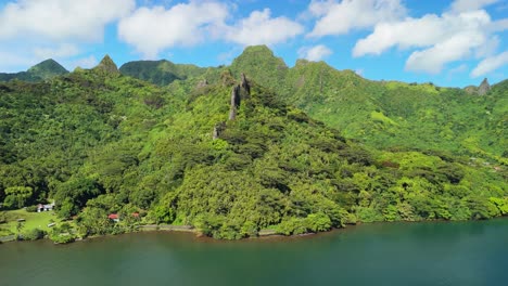 drone rising over the mountains of moorea with ocean inlet seen in the foreground