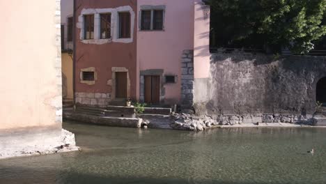 Calm-waters-in-the-canal-inside-the-old-town-Annecy-with-medieval-architecture-and-wild-life---common-duck-in-water