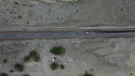 Drohnenaufnahme-Eines-Nach-Unten-Gerichteten-Winkels-Eines-Tuk-Tuk,-Das-Auf-Einer-Autobahn-In-Pakistan-Fährt