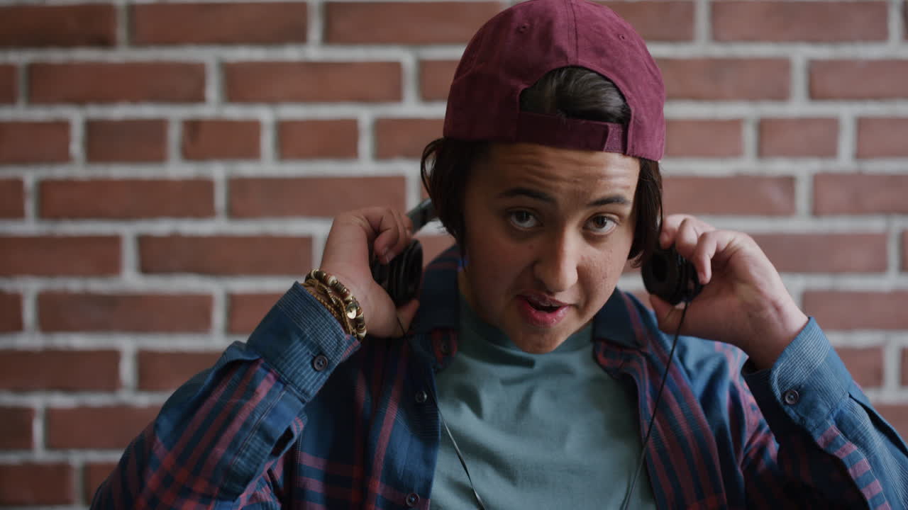 retrato relajado joven estudiante universitario hombre se pone auriculares disfrutando escuchando música sonriendo satisfacción feliz cámara lenta