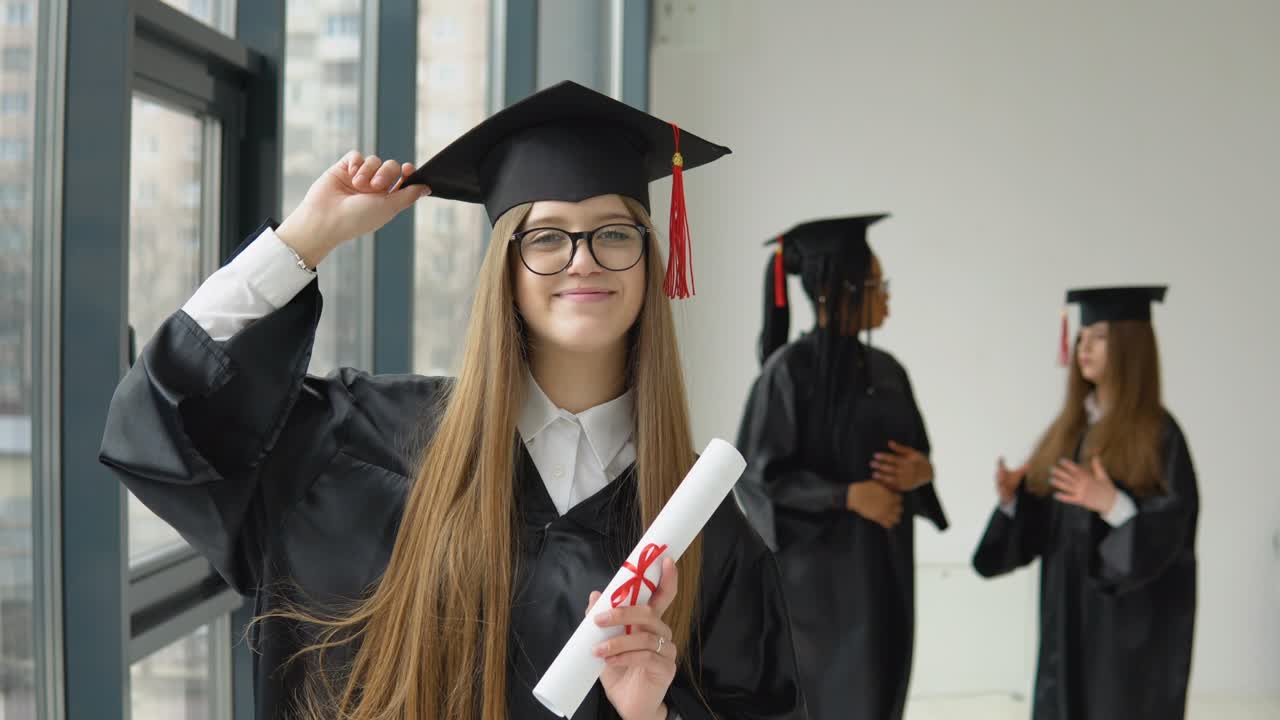 graduada alegre con una mano sostiene un diploma, y con la otra mano sostiene un sombrero en el fondo de dos estudiantes de diferentes razas. la educación superior está disponible para las mujeres de clase media