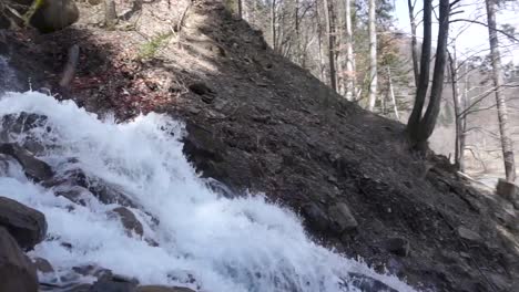 pan shot of roaring waterfall on the hill