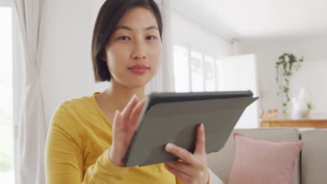 portrait of happy asian woman using tablet in living room