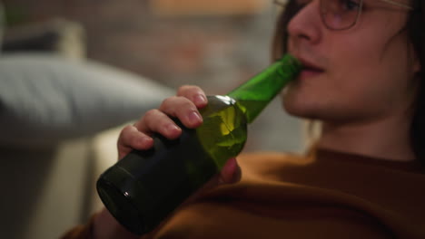 long haired hipster drinks cool beer enjoying football match