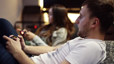 pareja joven jugando videojuegos en casa. disparar y controlar usando el controlador de juego. controlador de juego inalámbrico. cámara lenta