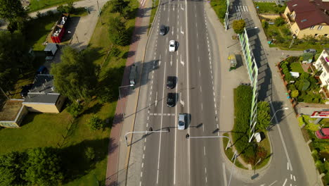 Aerial-tilt-up-on-green-suburban-neighborhood-with-intersection-and-cars-at-traffic-light