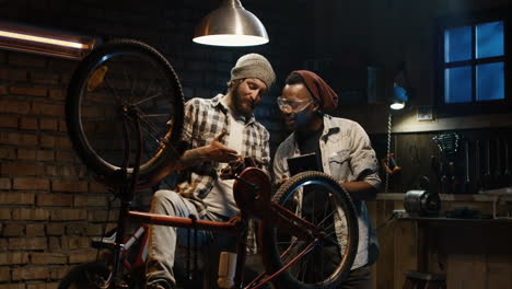 two men fixing a bicycle in a garage