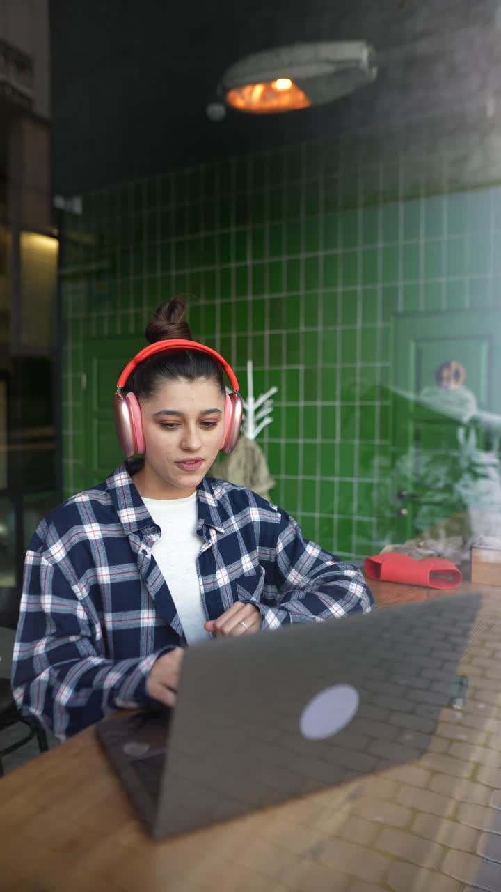 mujer trabajando en una computadora portátil en un café