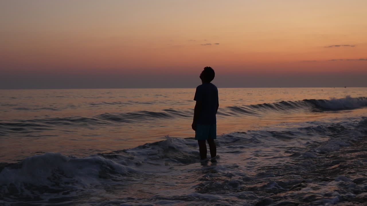Uomo depresso sulla spiaggia al tramonto