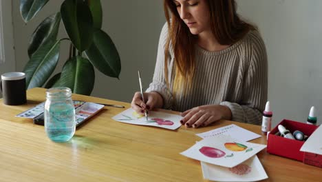 young girl painting watercolor drawings