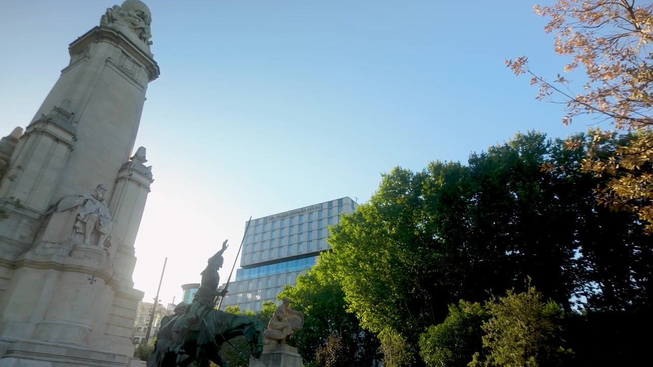 Vista de baixo ângulo do histórico monumento de Cervantes e da estátua de bronze de Dom Quixote na Praça de Espanha, em Madrid, Espanha. Útil para documentários de viagem e conteúdo de turismo europeu.