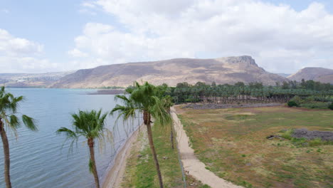 the sea of galilee and the golan mountains in a cloudy summer afternoon - arial sliding shot