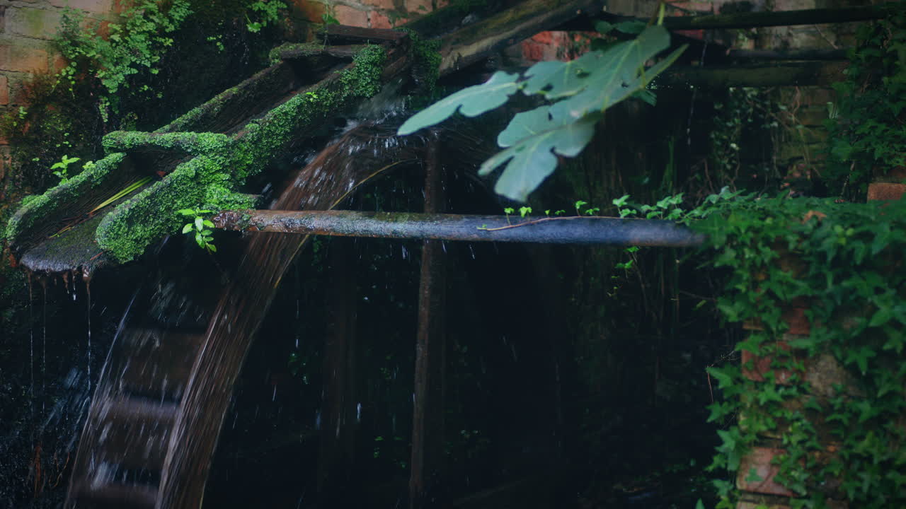 molino de agua rústico cámara lenta de primer plano disparo de agua golpeando el molino