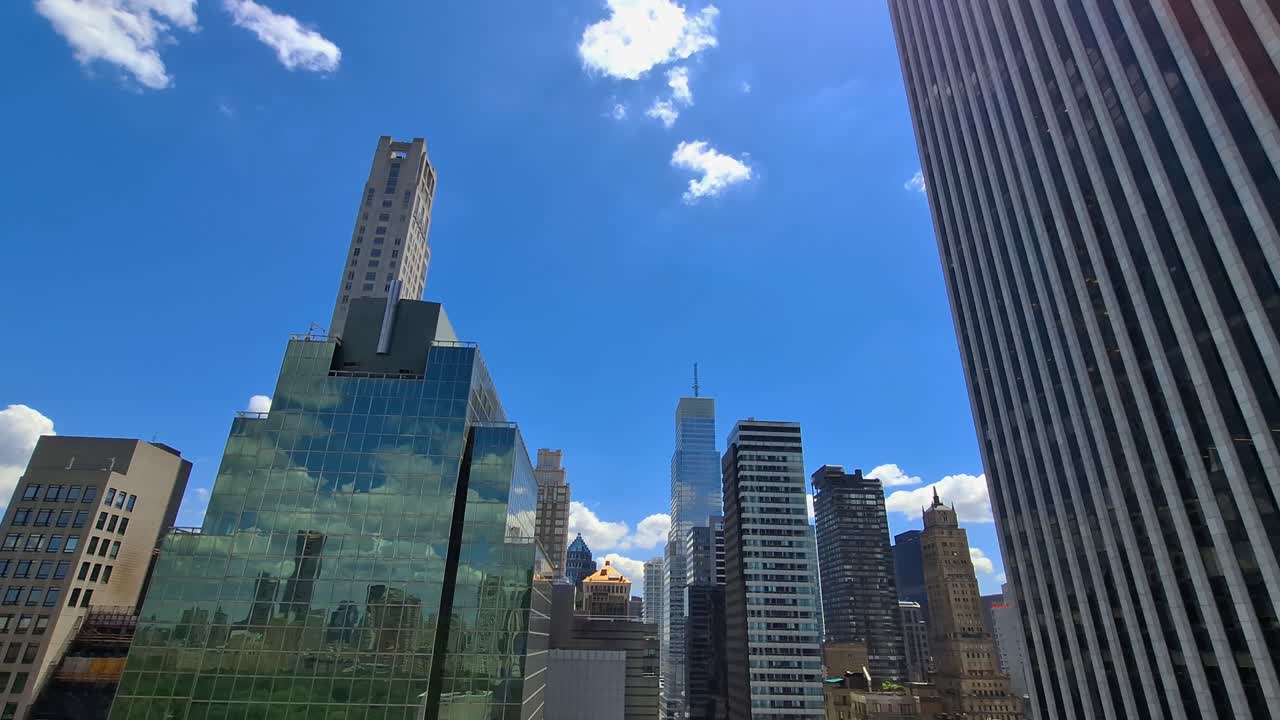 Aerial and ground views of tall glass skyscrapers and rooftops reflecting sunlight in Midtown Manhattan, New York, United States