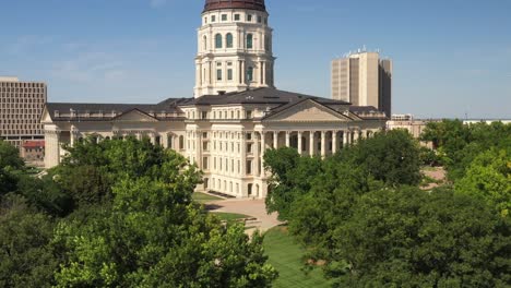 kansas state capitol building in topeka, kansas with close up drone video moving up with trees