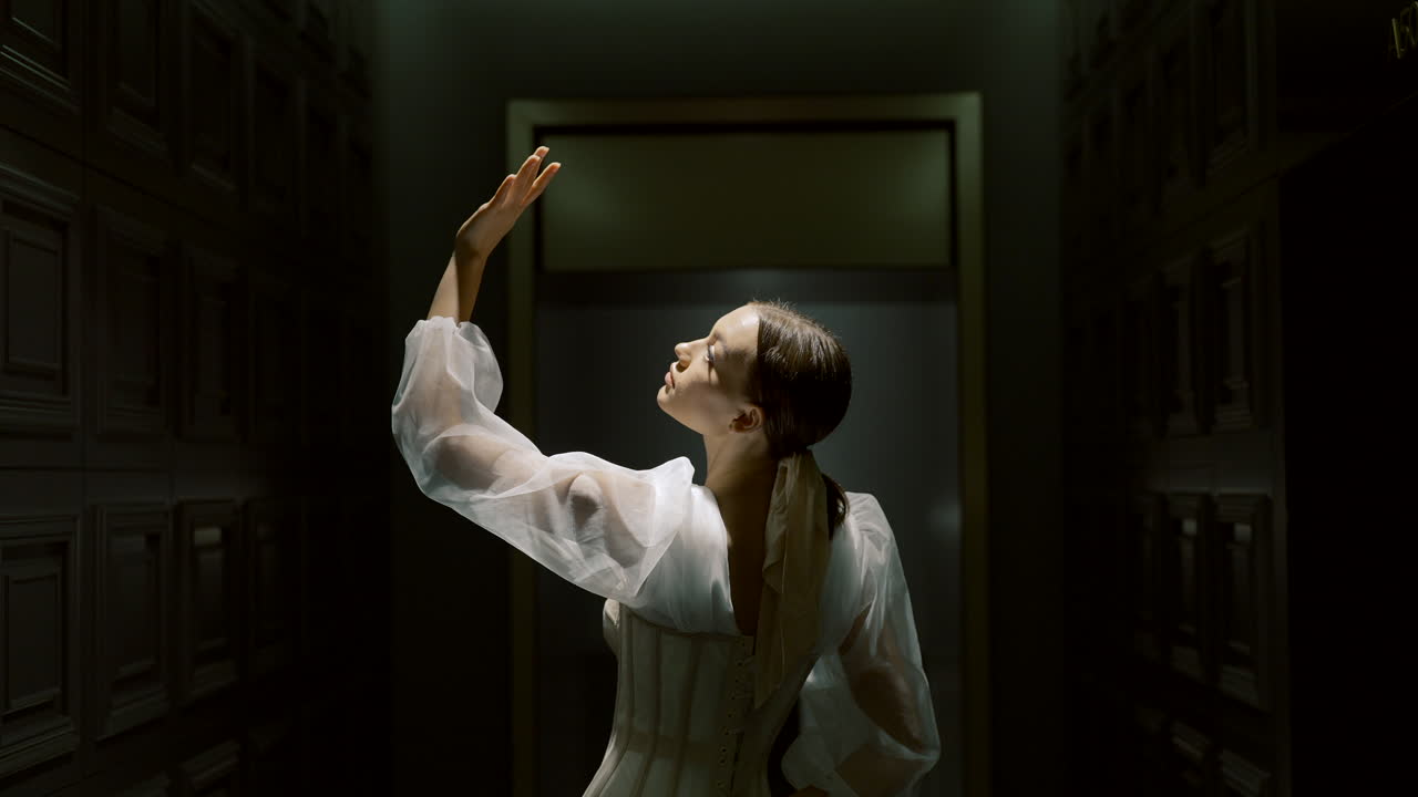 mujer en elegante vestido de corsé en el corredor oscuro