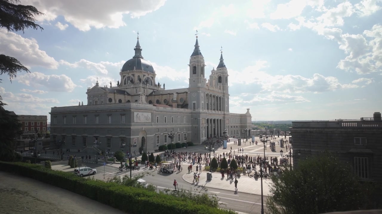 Vista della Cattedrale dell'Almudena di Madrid in una soleggiata giornata estiva con turisti e città affollata