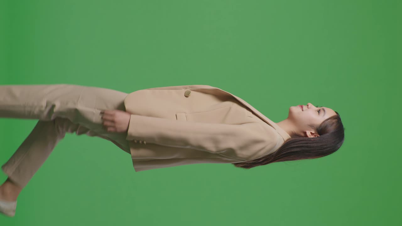 녹색 스크린 크로마 키에서 돌아다니고 둘러보는 아시아 사업가의 측면 시각