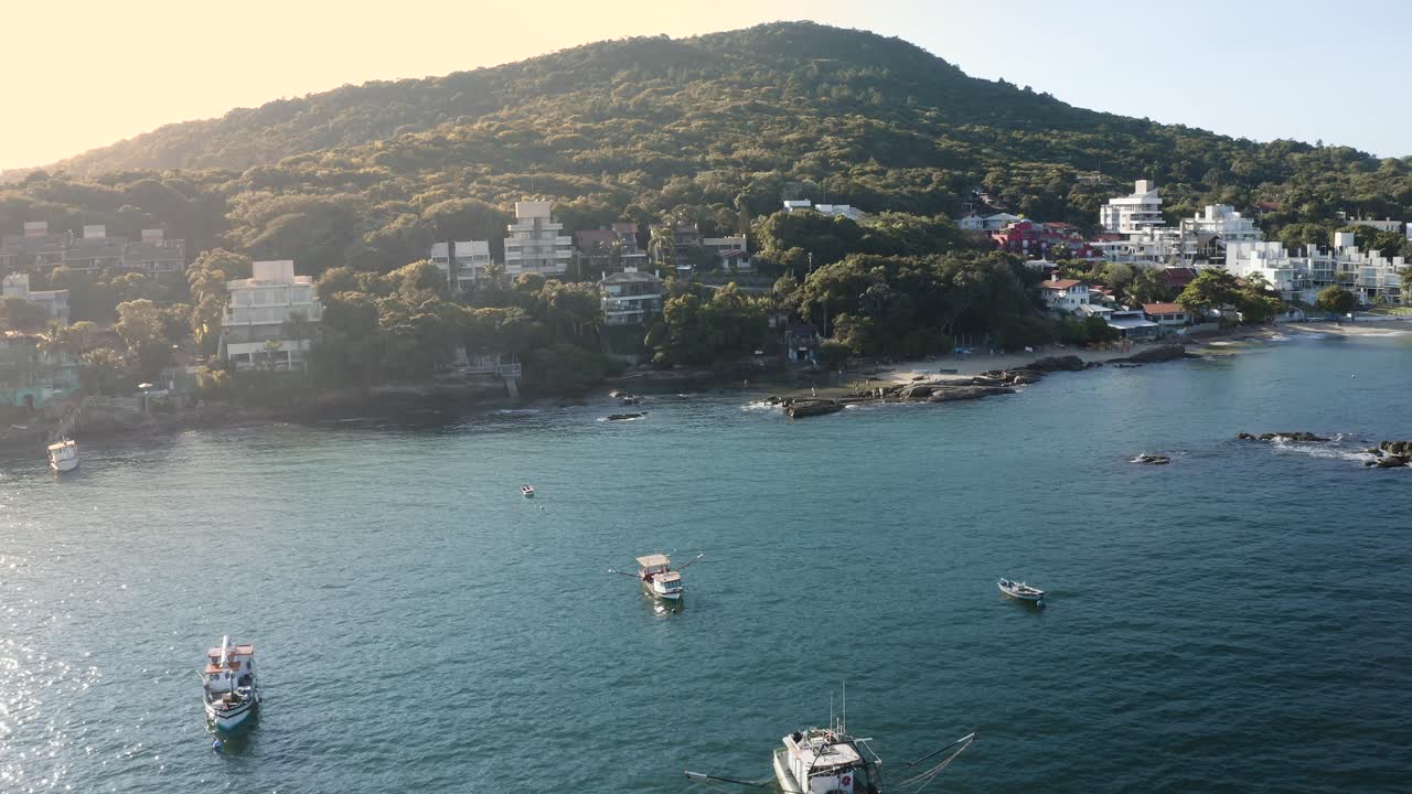hermosa vista aérea cinematográfica de drones que se distancia sobre el océano de una playa paradisíaca brasileña con arena blanca y agua cristalina esmeralda al amanecer