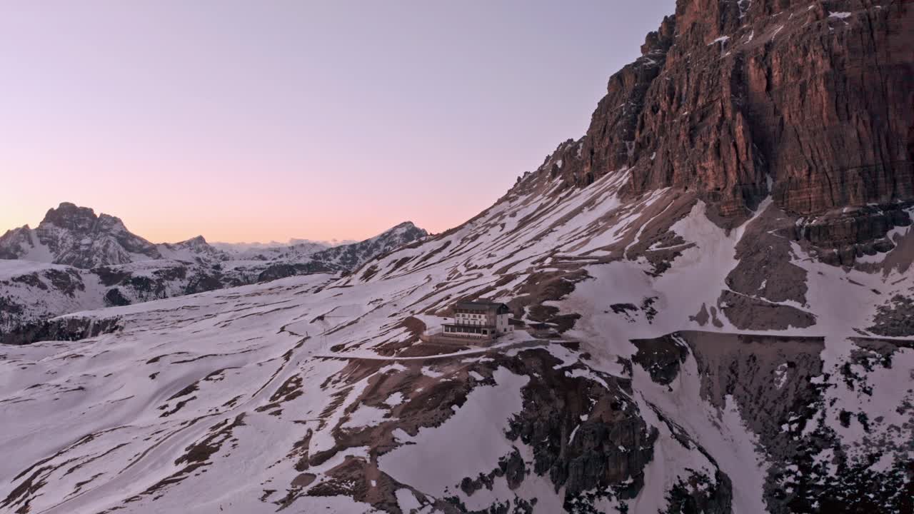 Establishing drone shot towards Refugio Auronzo Tre Cime Dolomites in winter