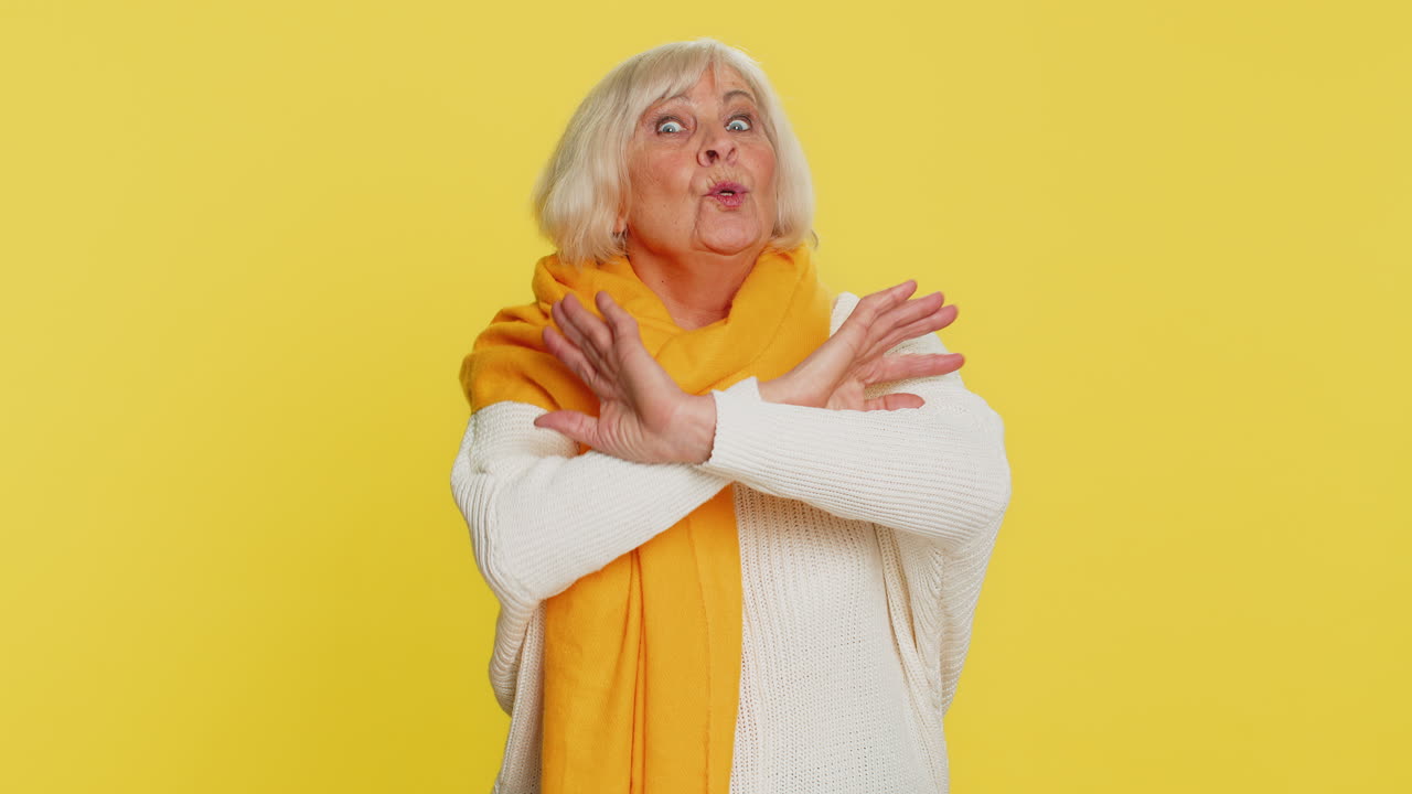 Annoyed irritated senior woman covering ears gesturing no avoiding advice ignoring noise loud voices