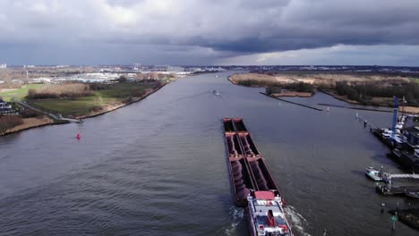 bulk carrier with multiple cargo hold loaded with coal and ore sailing on oude maas river near puttershoek in netherlands