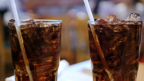 El-Hormigueo-De-Coca-cola-En-Un-Vaso-Frío-Sobre-La-Mesa-En-El-Restaurante