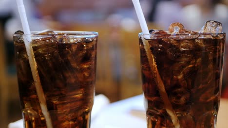 the tingling of coca-cola in a cold glass on the table in the restaurant