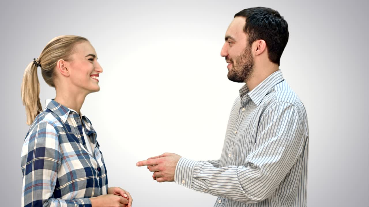 hombre guapo y mujer joven atractiva hablando y sonriendo sobre un fondo blanco