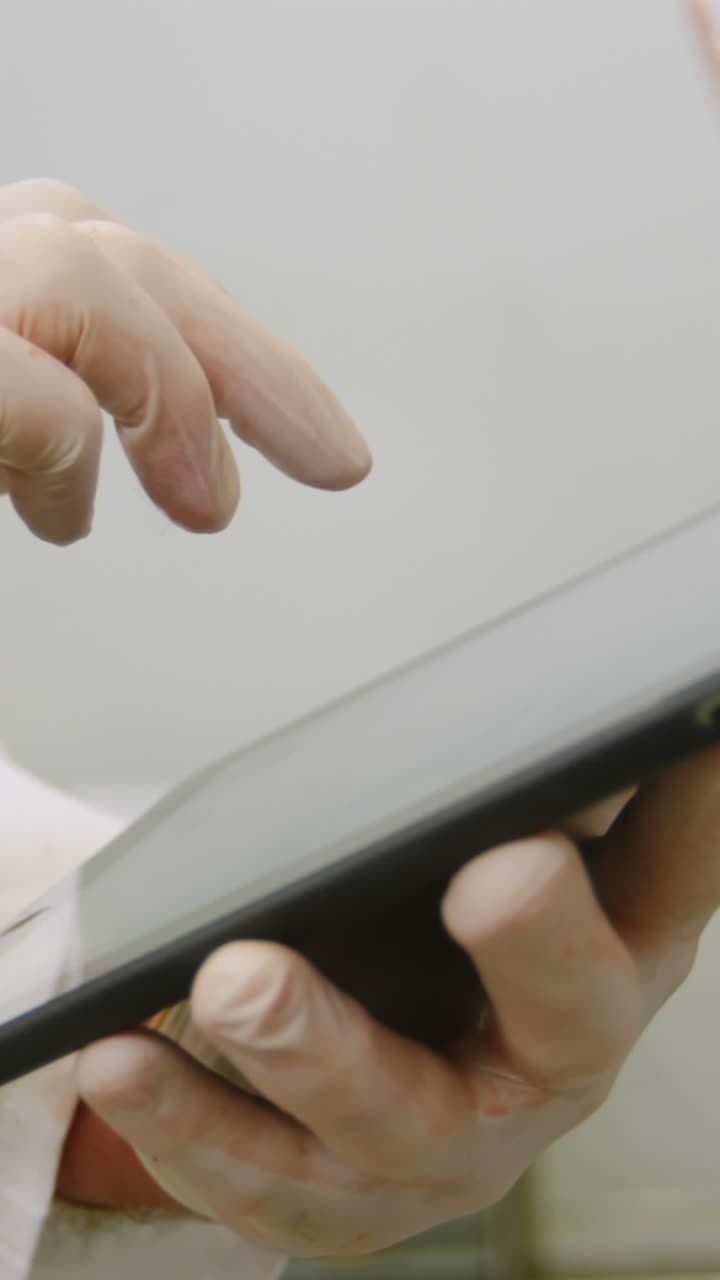 carnicero usando una tableta digital en la sala de almacenamiento de carne