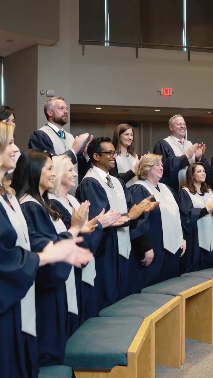 Vertical video: Clapping choir dropping hands, following leader cue in church, navy robes, stoles