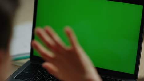 Boy-having-video-call-with-mockup-computer.-Child-looking-green-screen-laptop.