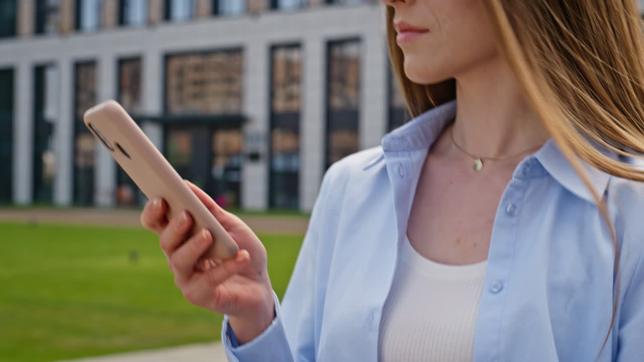 Girl browsing app mobile phone walking urban street closeup. Woman reading