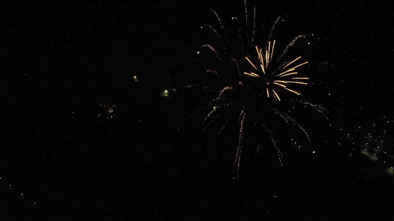 Slow Motion Aerial of Fireworks Over Small Town