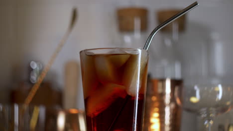 Metal-straw-dropping-in-to-pint-glass-full-of-soda